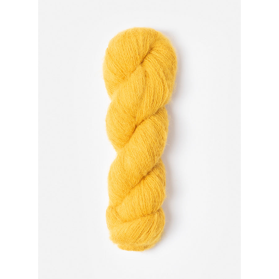 A skein of Blue Sky Fibers Prairie in Chamomile, a golden yellow