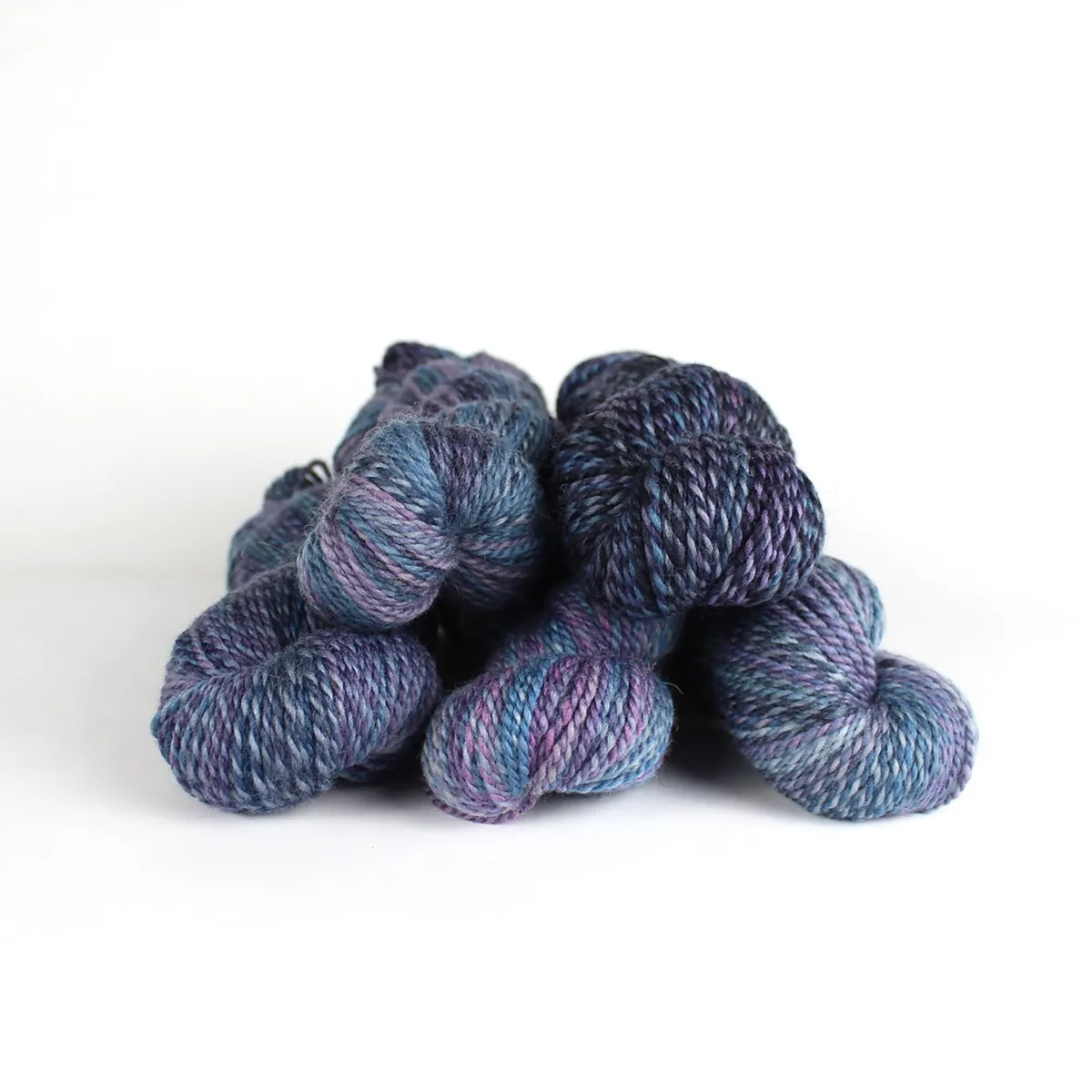 Five skeins of JFM Making Tracks Constellation, variegated with muted purples and blues 