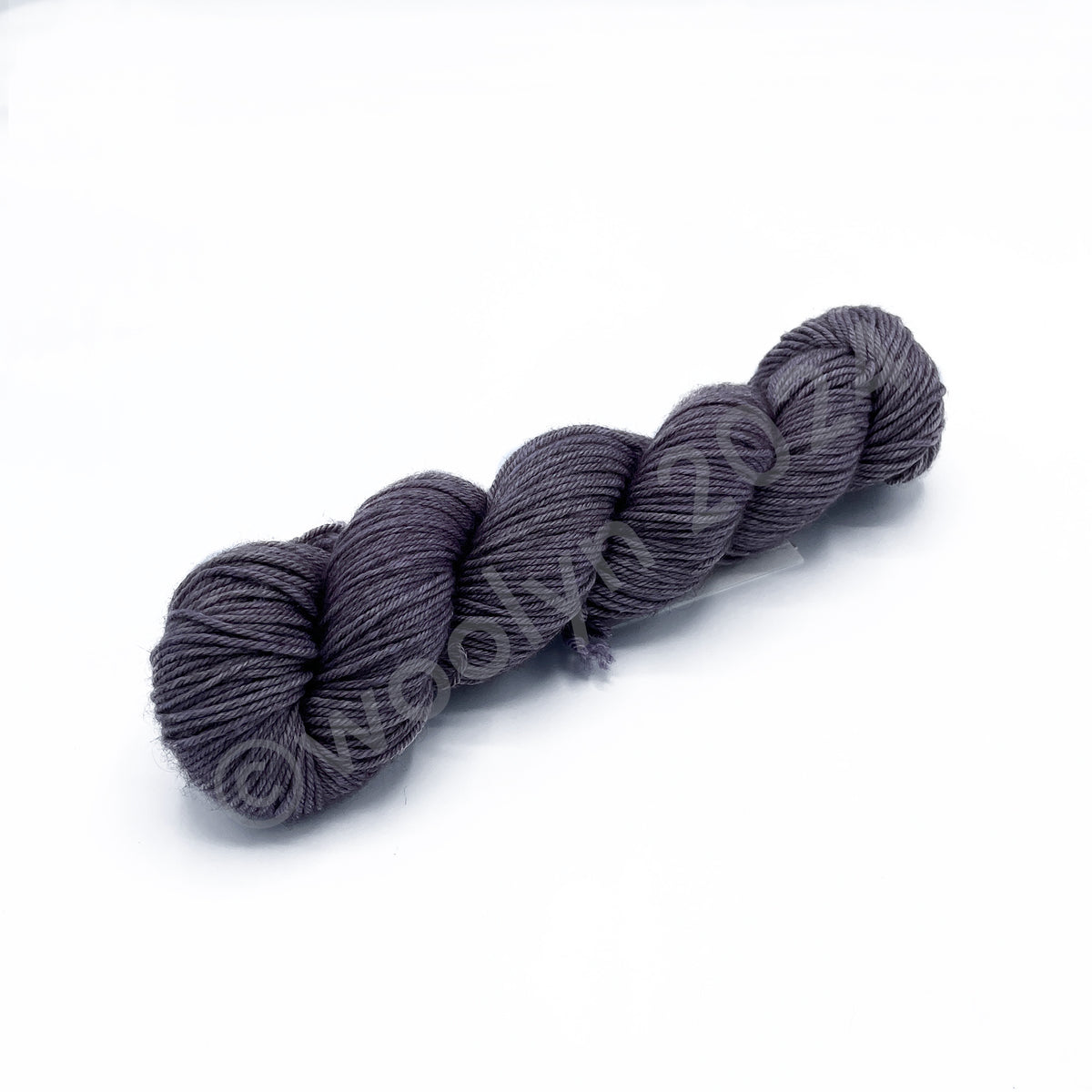 A skein of Woolerton Estates Distinguished Edwina, a deep greyish lavender color.