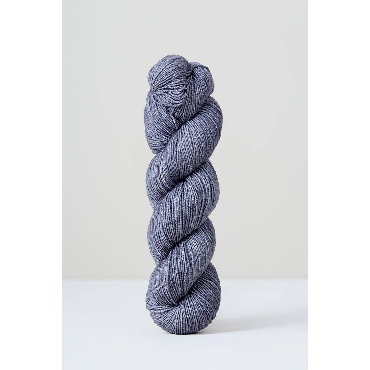 A skein of Urth Harvest Fingering Mint, a steel grey color with blue undertones.