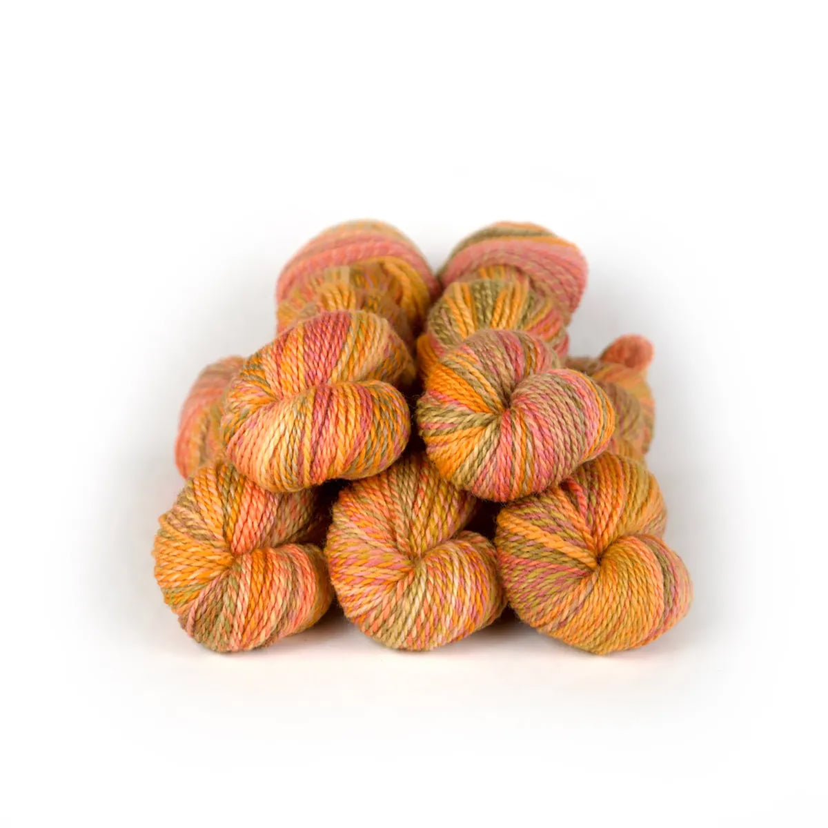 Five skeins of JFM Making Tracks Pumpkin Patch, variegated earthy pink, yellow, orange, and green 