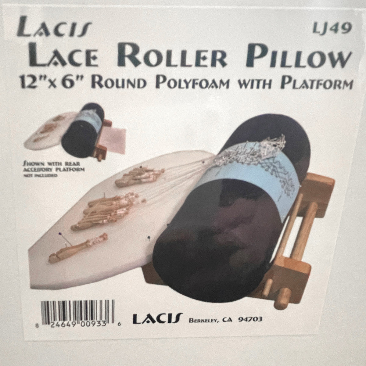 A photo of the Lacis Lace Roller Pillow box containing a 12”x6” round polyfoam cushion and a wooden platform.