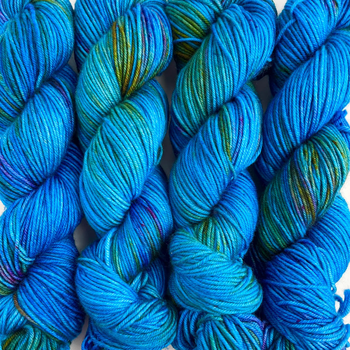 Skeins of Tributary Tidal DK South Fork, variegated teal, olive green, rust, and purple