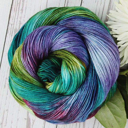 Yarn Love Amy March in Magic Forest a variegated teal, green, purple and red color.