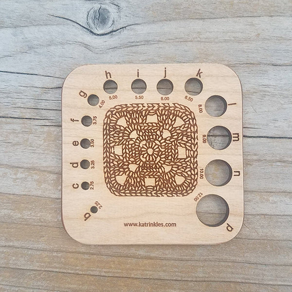 Wooden needle/Hook Gauge with a granny square on it. Measures approximately 3&quot; x 3&quot;.