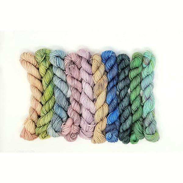 10 mini skeins of Jade Sapphire Coloring Box Thunder Egg-and pattern booklet in muted shades of pink, beige, green and blue. 