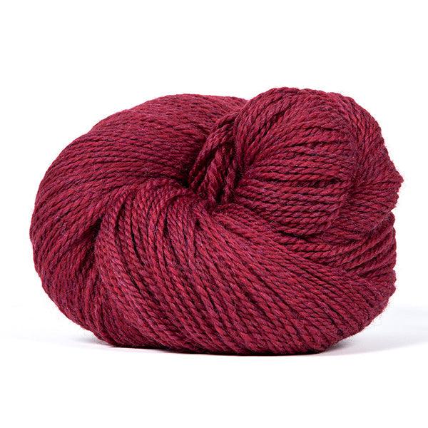 A skein of Kelbourne Woolens Scout Scarlet Heather 614, a heathered dark red. 