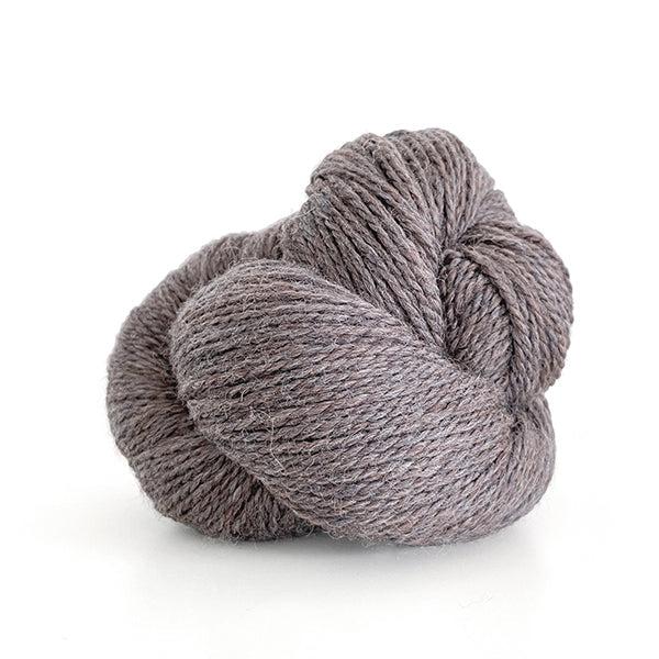 A skein of Kelbourne Woolens Scout Stone Heather 43, a heathered medium warm grey.