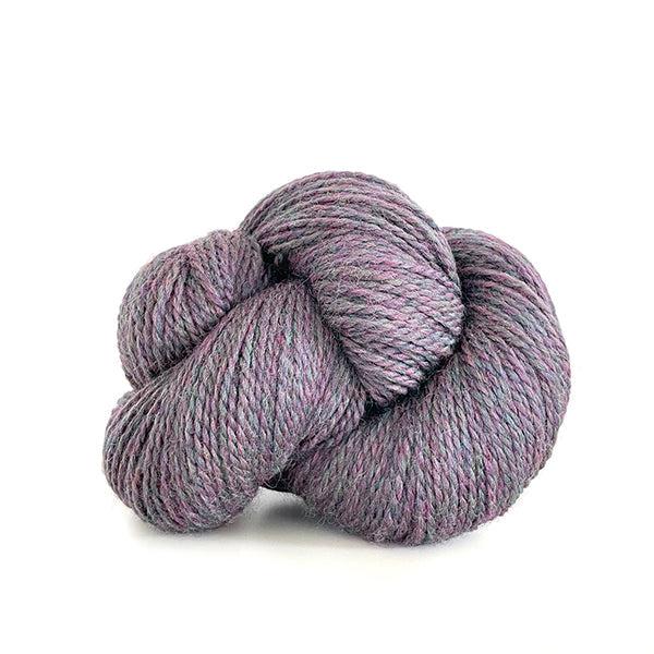 A skein of Kelbourne Woolens Scout Wisteria Heather 515, a heathered pale purple with grey.