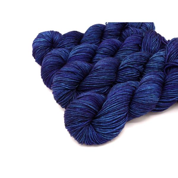 Skeins of Murky Depths Neptune DK Electric Ladyland, a slightly tonal deep indigo blue yarn with overtones of purple. 