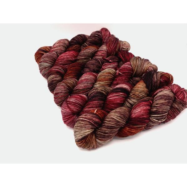 Skeins of Murky Depths Neptune DK Gigli, a variegated yarn n shades of dark red, light and medium warm brown.  