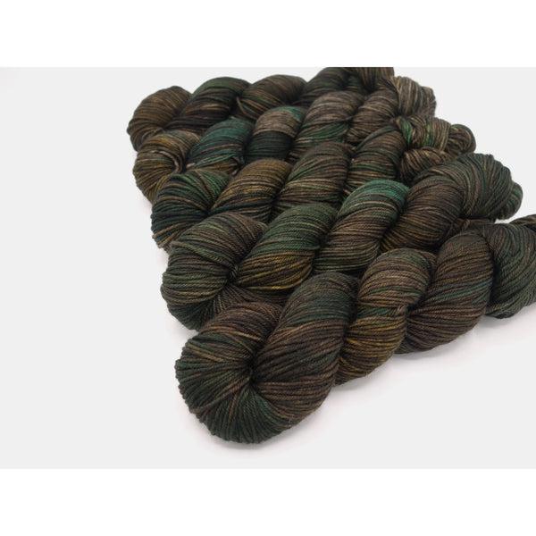 Skeins of Murky Depths Neptune DK Tweed Blazer, a tonally variegated yarn in shades of brown and hunter green.